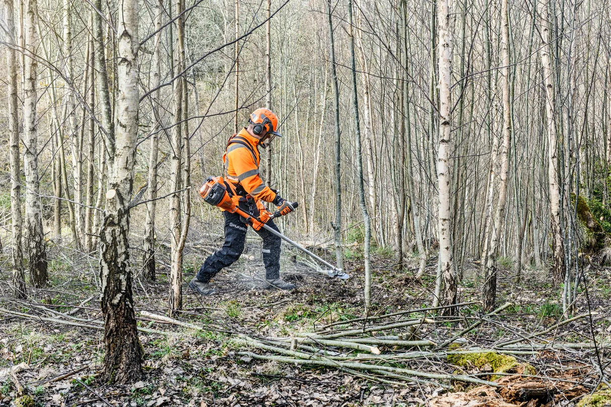 Husqvarna 545FXT AutoTune raivaussaha käytössä metsässä, tehokas työkalu metsänhoitoon ja raivaustöihin.