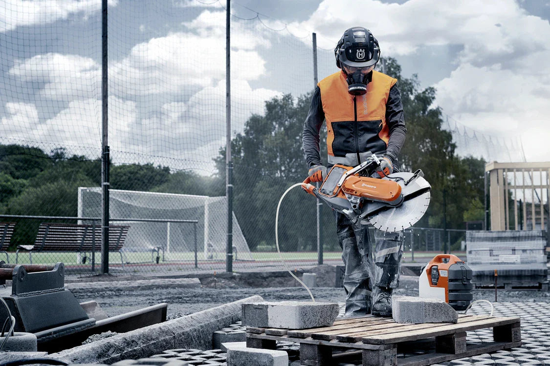Husqvarna laikkaleikkurit: Ammattimainen työntekijä käyttää Husqvarna K970 III laikkaleikkuria työmaalla, paloittain lohkareita leikatessa.