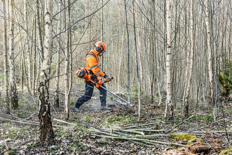 Husqvarna 545FXT AutoTune raivaussaha käytössä metsässä, tehokas työkalu metsänhoitoon ja raivaustöihin.